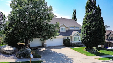 View of front facade featuring stone siding, concrete driveway, and roof with shingles