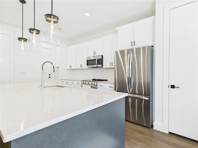 Kitchen featuring stainless steel appliances, dark