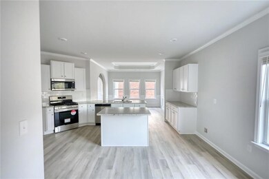 Kitchen featuring arched walkways, light wood-type