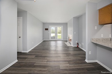 Unfurnished living room with a fireplace with flush hearth and dark wood-style floors