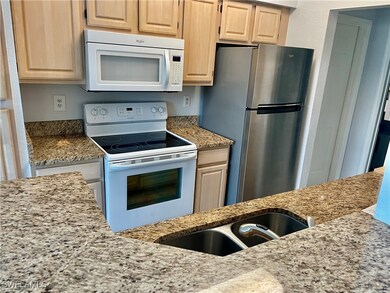 Kitchen featuring light stone counters, light brow