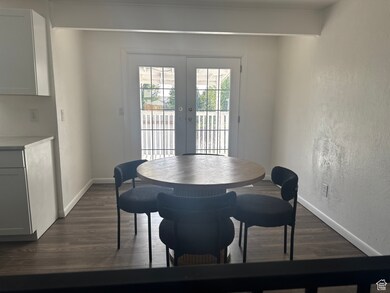 Dining space featuring dark wood-style flooring, baseboards, and french doors