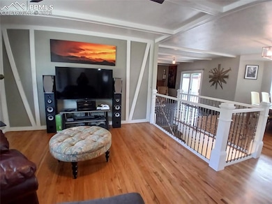 Living room featuring hardwood flooring and beam ceiling