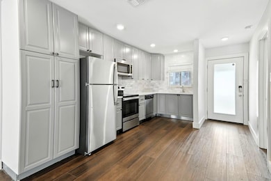 Kitchen featuring dark wood-type flooring, stainl