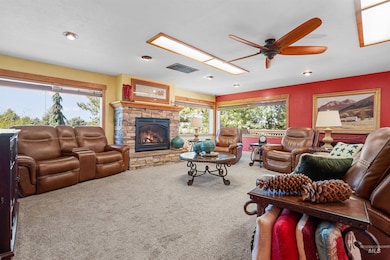 Carpeted living room featuring a ceiling fan, a fireplace, plenty of natural light, and recessed lighting