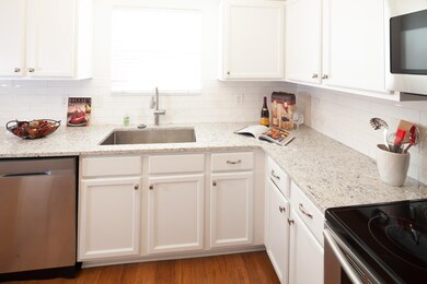 In front of this window facing your green backyard and distant trees is a large and deep one-hole sink. The countertops are granite.