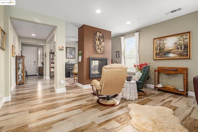 Living area with recessed lighting, light wood-type flooring, and a multi sided fireplace