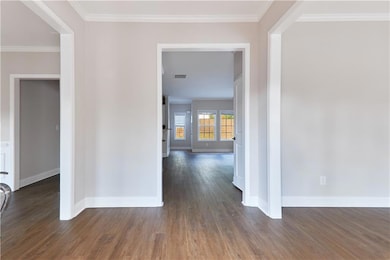 Hallway with crown molding and dark wood-type flooring