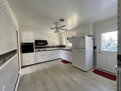 Kitchen featuring a sink, wallpapered walls, and a