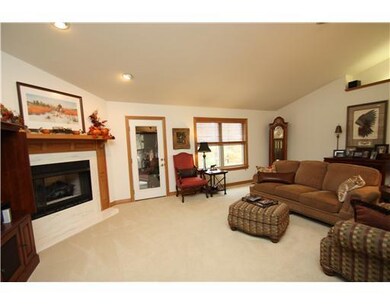 Living Room. A cozy corner fireplace adds warmth and charm to this open living room that connects to sunroom.