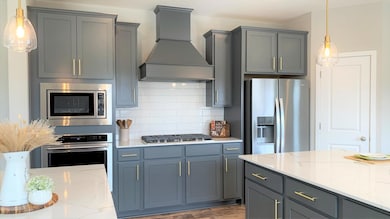 This home features our gourmet KitchenAid appliance package with wood hood, 36
