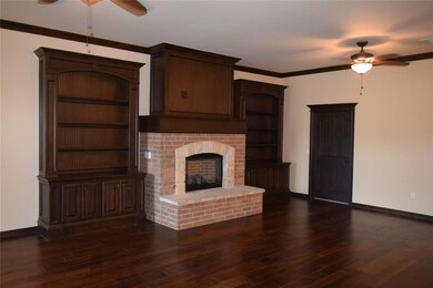 Unfurnished living room featuring a ceiling fan, baseboards, dark wood-style flooring, and crown molding