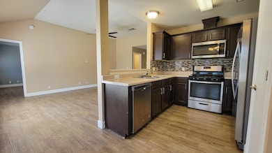 Kitchen with light wood-type flooring, a sink, ap