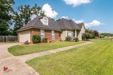 View of front of home featuring brick siding, roof with shingles, driveway, and a garage