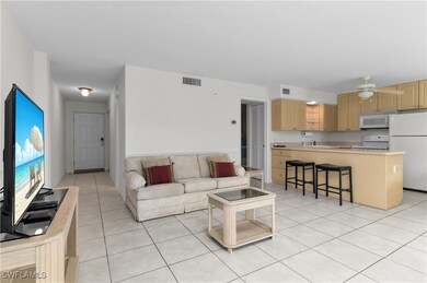Living room featuring light tile patterned flooring, ceiling fan, and a textured ceiling