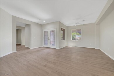 french doors, light LVP wood-style floors, baseboa