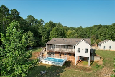 Rear view of property featuring a yard and a pool