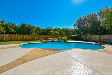The pool is large and is sparkly blue!  It has an elevated tanning platform area and a rock water fall! This home has one of the largest lots in Village Crest.