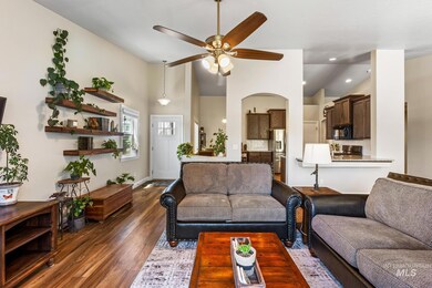 Living area with lofted ceiling, ceiling fan, wood finished floors, recessed lighting, and arched walkways