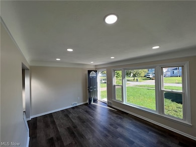 Empty room featuring dark hardwood / wood-style floors