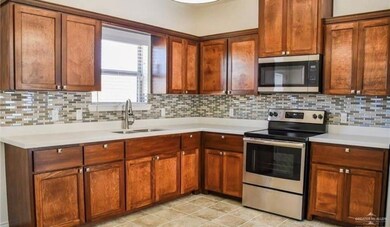 Kitchen featuring sink, appliances with stainless steel finishes, and tasteful backsplash