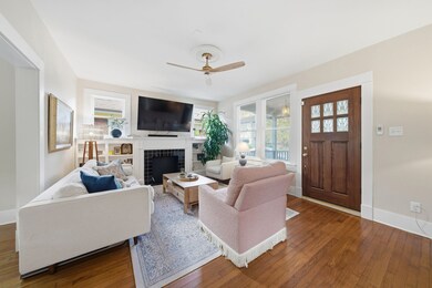 Bright and inviting living room with hardwood floors, large windows, and a mock fireplace.  Perfect for relaxing and great layout to kitchen and dining.