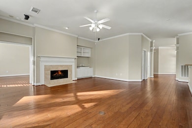 Open family room with cozy gas log fireplace complete with mantle and built-ins, speakers as well.