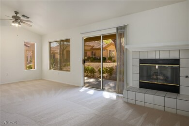 Living room with ceiling fan, new carpet, vaulted