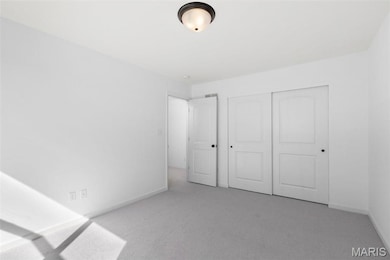 Unfurnished bedroom with light colored carpet and a closet