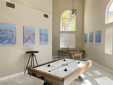 Playroom with a towering ceiling, marble look tile