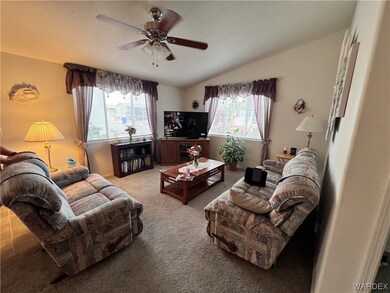 Carpeted living room with ceiling fan, plenty of n