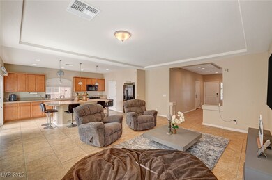 Living area featuring a tray ceiling, light tile p