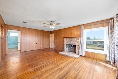 Living room with panelling, ceiling fan, a firepla