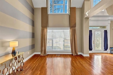 Foyer with a towering ceiling and light wood-type flooring