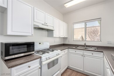 Kitchen featuring a sink, dark countertops, under