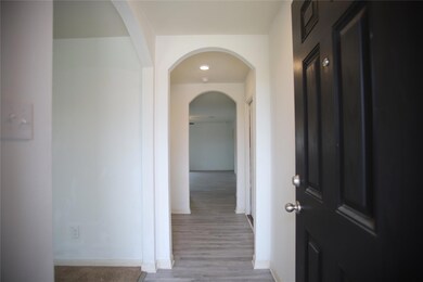 Corridor featuring arched walkways, baseboards, a