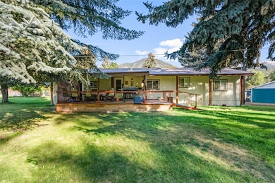 Front  view of property with a lawn, a deck, and a metal roof