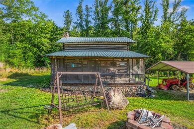 Cabin view, firepit, and detached carport