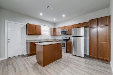 Kitchen with visible vents, light wood-style floo