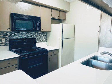 Kitchen featuring backsplash, black appliances, li