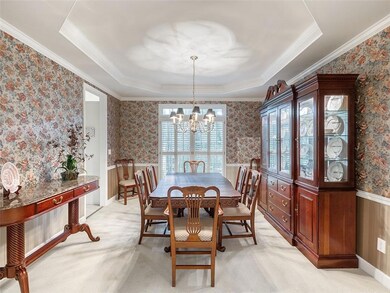 Dining area with a chandelier, a raised ceiling, w