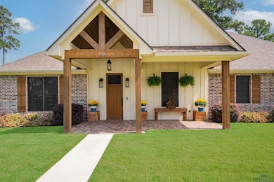 View of front of home featuring board and batten siding, a shingled roof, a front lawn, and a porch