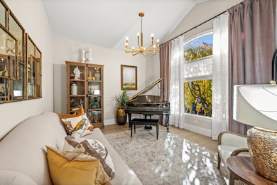 Living area featuring a chandelier, wood finished floors, and vaulted ceiling