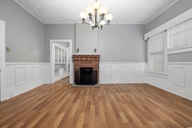 Unfurnished living room featuring a chandelier, wood-type flooring, and a textured ceiling