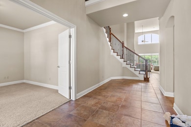 Entryway featuring stairs, ornamental molding, re