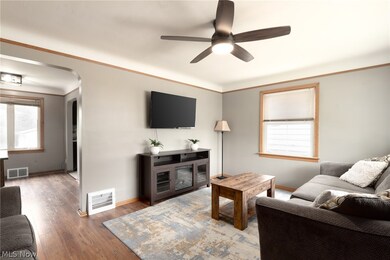 Living room featuring ornamental molding, ceiling fan, hardwood / wood-style flooring, and a wealth of natural light