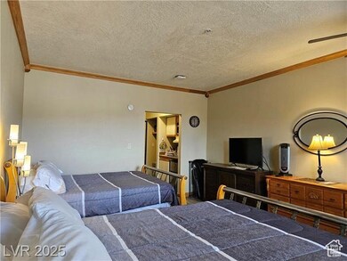 Bedroom featuring ornamental molding and a textured ceiling