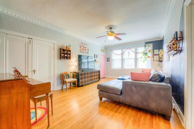 Living area featuring crown molding, a ceiling fan