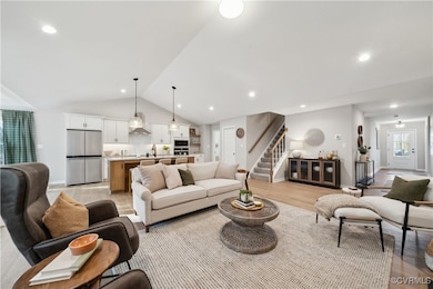 Living room with stairs, light wood-style flooring