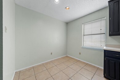 Unfurnished dining area featuring a textured ceiling, light tile patterned flooring, and recessed lighting